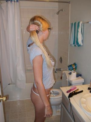 16P Blonde amateur Elle brushes her hair in glasses and thong while in a bathroom