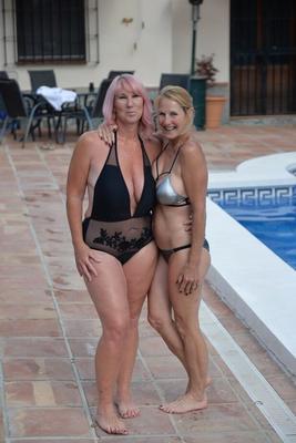 20P Mature amateurs share a lesbian kiss in their swimwear on poolside patio