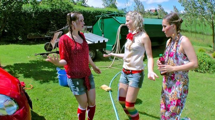 14P Young girls soak each other in a backyard while washing a compact vehicle
