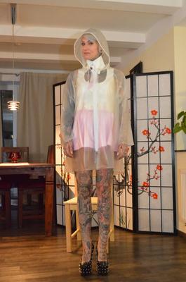 16P Tattooed platinum blonde Miss Francine models a raincoat over a latex dress