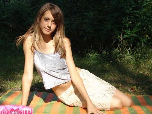 10P Une jeune fille expose son nombril sur une couverture près de quelques arbres