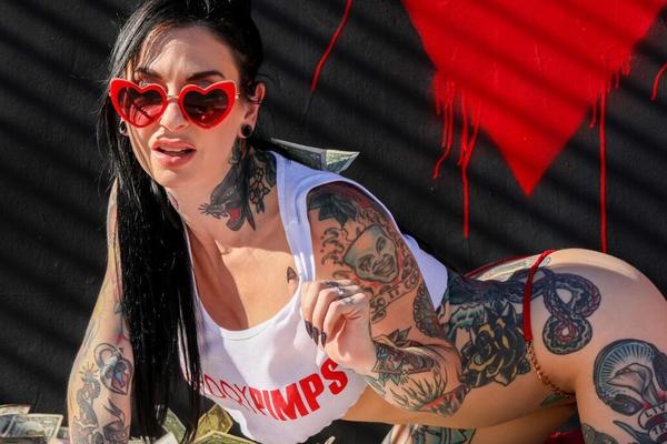 21P, la MILF américaine encrée Joanna Angel pose dans son haut blanc et sa culotte rouge.