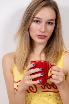 20P Young blonde Karolina casts off her shirt to get totally naked on a table