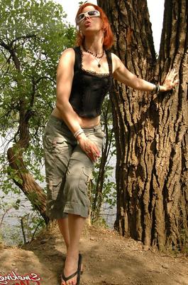 15P Sexy redhead Mina wears long shorts and sunglasses while smoking in woods
