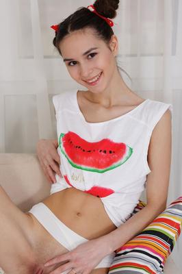 20P Adorable teen Leona Mia licks her lips while getting naked in puffballs