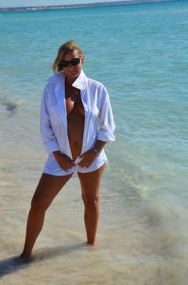 20P Blonde amateur Sweet Susi steps into the ocean while naked in a white shirt