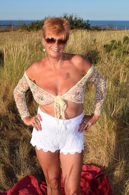 20P Fit older lady Dimonty exposes big naturals on a blanket overlooking the ocean