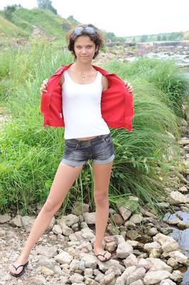 20P La petite adolescente Tina montre sa chatte chauve alors qu'elle est assise dans un ruisseau