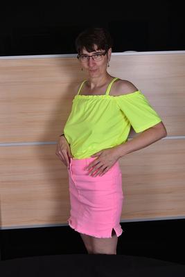 16P Mature woman undoes the snap and zipper on a pink miniskirt during SFW action