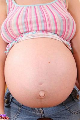 15P Pregnant amateur strips to her socks on a couch in a confident manner