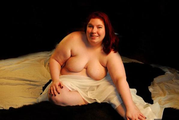 14P Redheaded amateur BBW Inked Oracle exposes her breasts on top of her bed