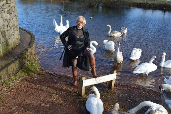 20P Mature blonde Barby Slut exposes her tits and twat in leather coat by a river