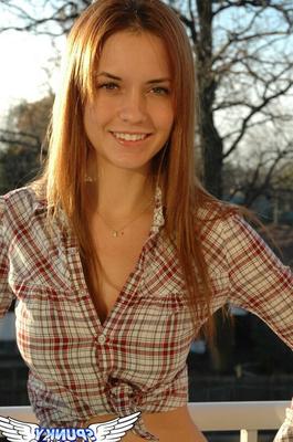 12P Redheaded country girl models non nude in tied up shirt and denim jeans