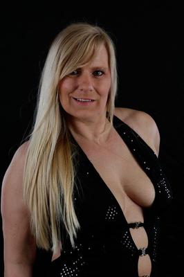 20P Older blonde Sweet Susi displays her inviting cleavage in a long gown