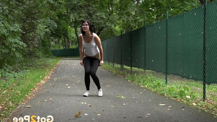 15P Glasses wearing chick pulls down her legging for a quick piss on on paved lot