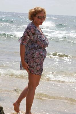 20P Fat mature lady Curvy Claire exposes her huge tits while kneeling in the ocean