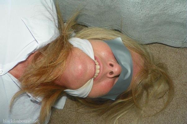 16P Blonde woman is cleave gagged and hogtied in a white blouse and blue jeans