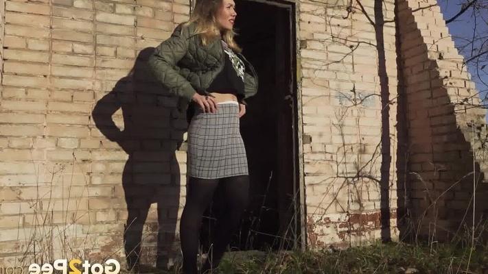 15P Caucasian female hikes up her skirt before pissing by a brick building