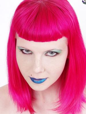 15P Goth model Szandora sticks out her pierced tongue while wearing a laced corset