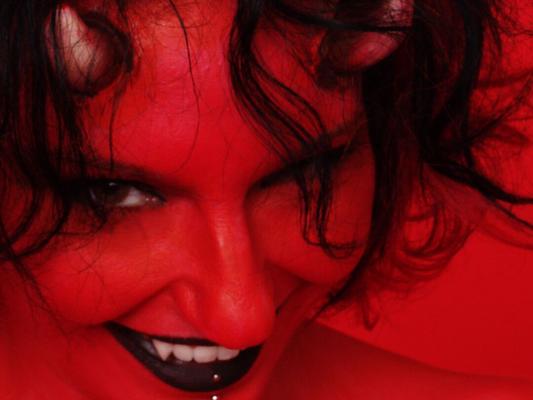 16P Tattooed and pierced chick Nina Sin sports a devilish look during a nude gig