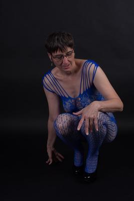 20P Un mannequin plus âgé pose dans un body sans entrejambe et des talons avec ses lunettes