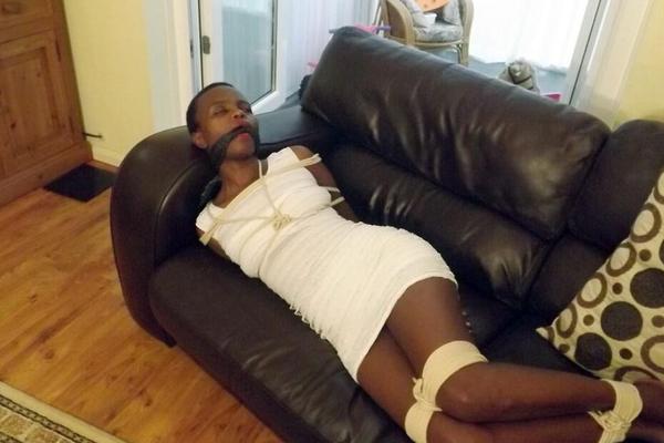 16P Black female is left tied and cleave gagged in a white dress on a leather sofa