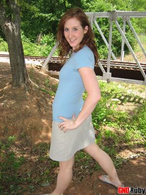 12P Pale redhead uncovers her small boobs near model railroad tracks