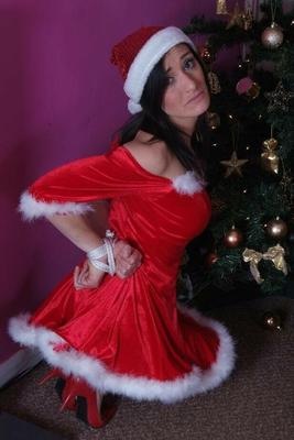 16P Dark-haired female Erin removes a ball gag while bound up at Christmas