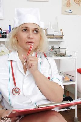 16P Older blonde nurse Sandy masturbating and toying bald cunt on exam table