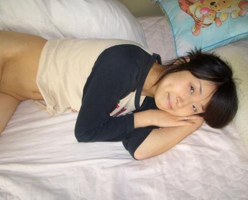 13P Cute Asian girl showcases her bald pussy while lying naked on her bed