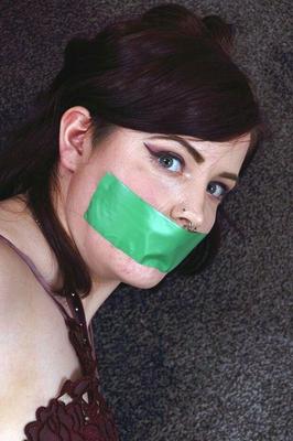 16P Clothed girl is silenced with a strip of tape over her mouth while tied up