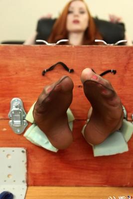 12P Natural redhead Sophie Nova removes her heels while her feet are in stocks