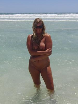 16P Middle-aged blonde Sweet Susi wades into the ocean while totally naked