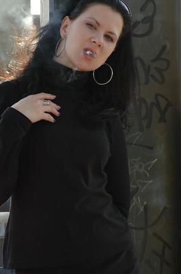 16P Fully clothed brunette lights up a cigarette with her sunglasses atop her head