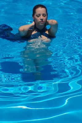 12P Busty redhead Ariel exits a swimming pool to pose totally naked