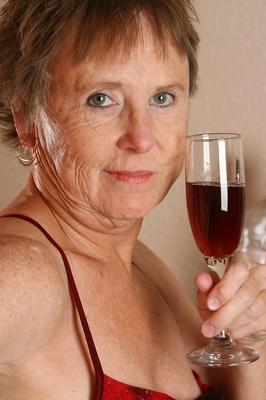21P Old granny with big tits Sandra D doffs her red dress and poses nude