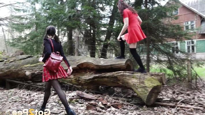 15P Sexy brunette takes a piss on a fallen tree while her girlfriend watches