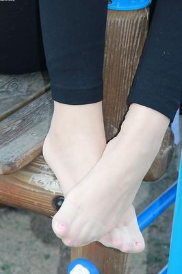 16P Lovely Christelle is showing her fine feet on a children playground