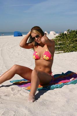 12P Chica amateur se pasea por la playa en bikini con estampado de flores y gafas de sol