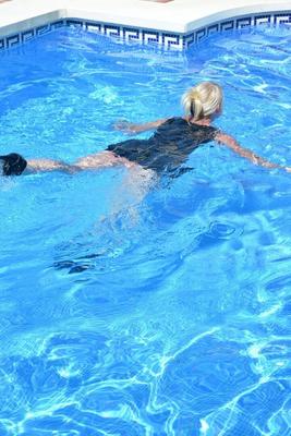 20P Thick blonde Melody displays her ample cleavage while fully clothed in a pool