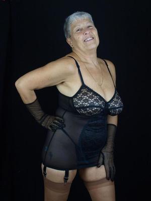 16P Silver haired woman Savana models lingerie and tan nylons while wearing gloves