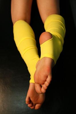 16P Caucasian female plays with her feet while wearing yellow leg warmers