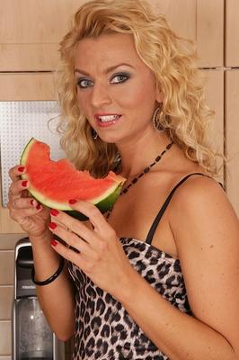 15P Blonde female Sophia Magic takes a bite of watermelon before disrobing at home