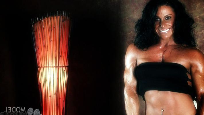 21P Brunette bodybuilder Debbie Bramwell flexing her strong body & her tight ass
