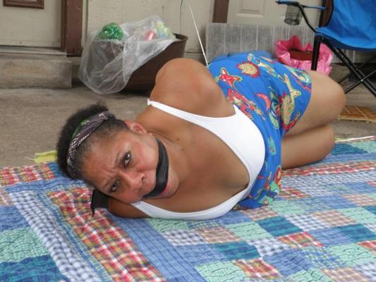 16P Mature ebony plumper is hogtied on a comforter while cleave gagged