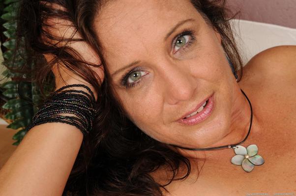 20P Mature brunette Chane sheds her corset & shows her tits & ass in sexy fishnets