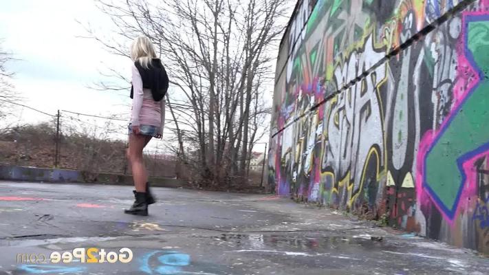 15P Blonde girl Claudia Macc pees on pavement near a wall of graffiti