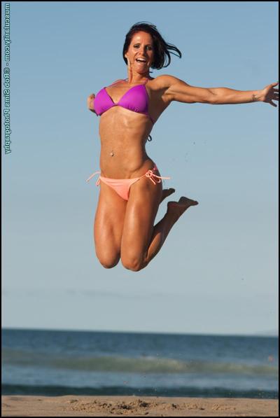 15P Sexy bodybuilder Toni Andra flexes on a beach while wearing a bikini