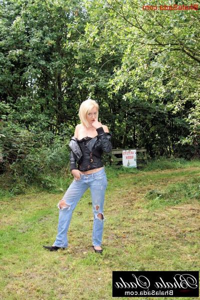 15P Little blonde babe poses in her corset, leather jacket and jeans outdoors