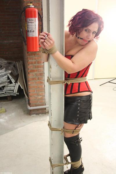 20P Corseted babe in boots Rani gets bound to a pole while ball gagged